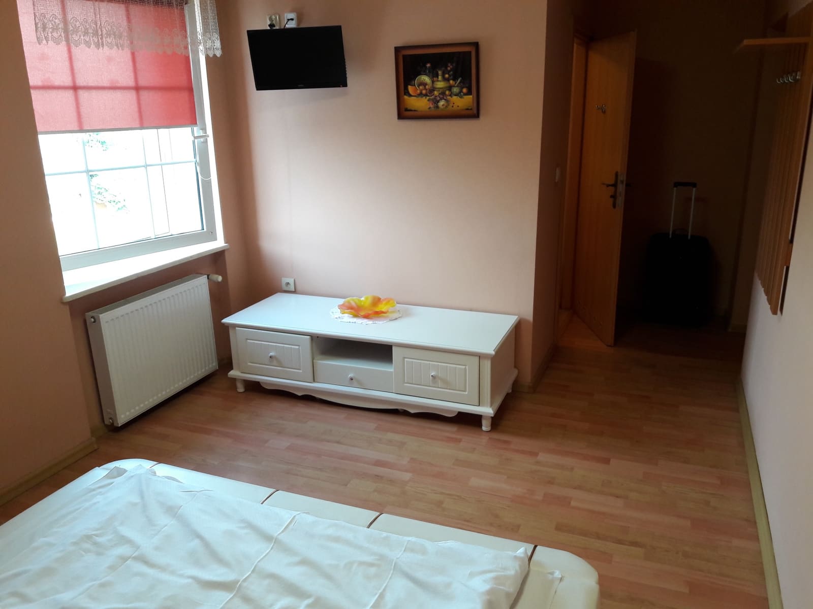 Jasny, przytulny pokój hotelowy z telewizorem i wygodnym łóżkiem