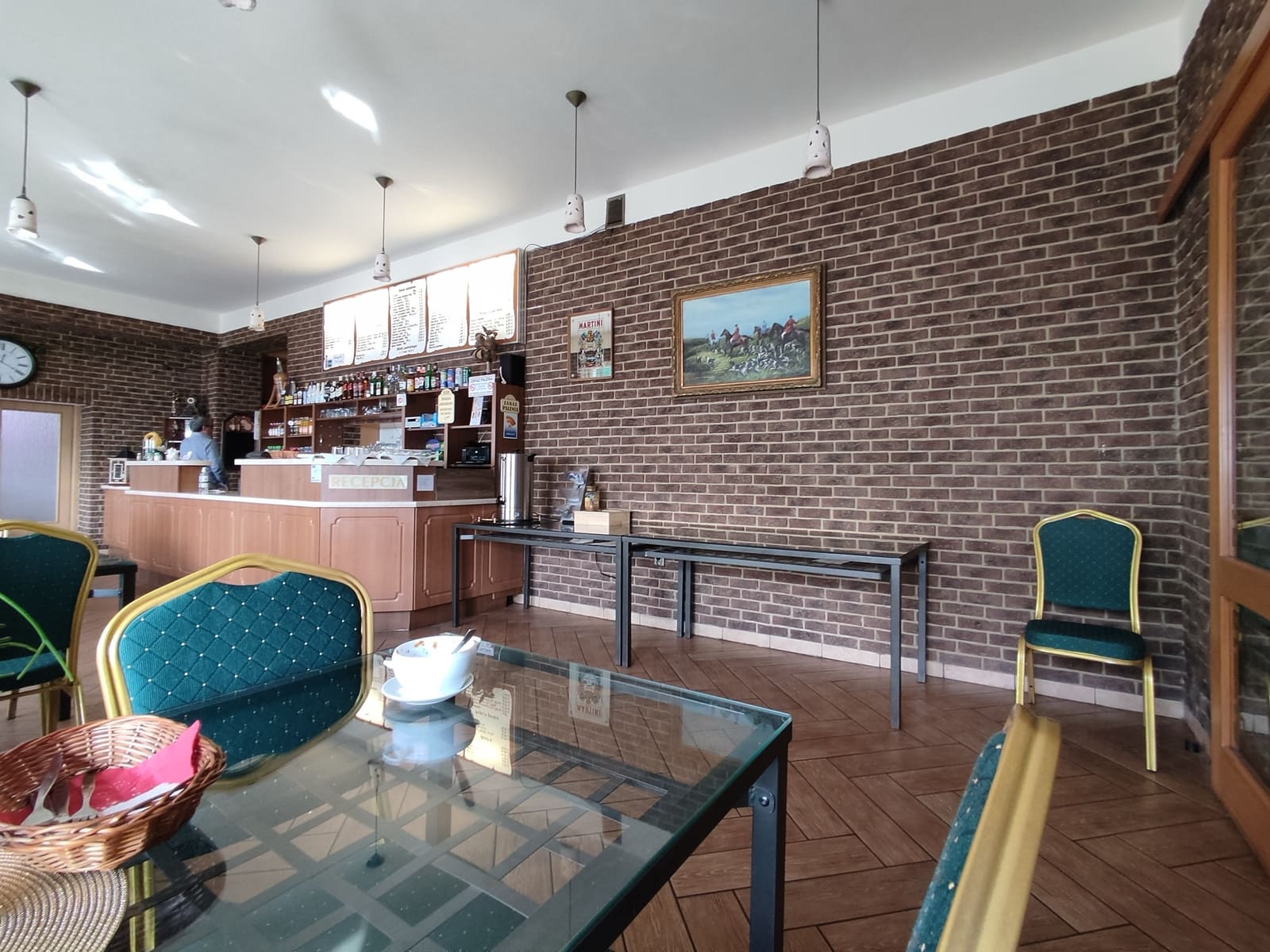 Recepcja i bar hotelu z ceglaną ścianą i przytulnym wystrojem
